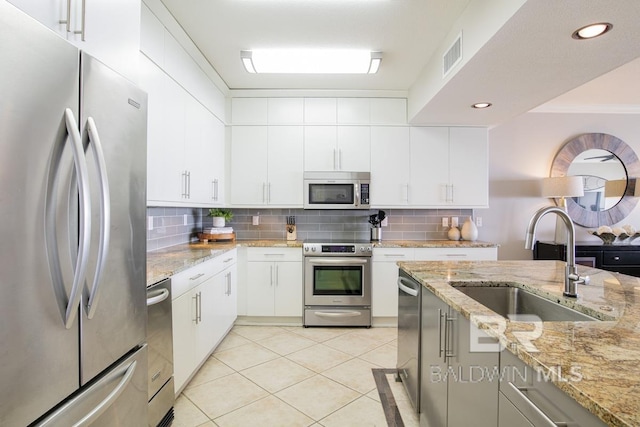 kitchen with a sink, visible vents, tasteful backsplash, and appliances with stainless steel finishes