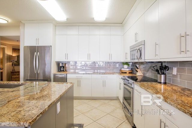 kitchen with light tile patterned flooring, tasteful backsplash, white cabinets, and stainless steel appliances