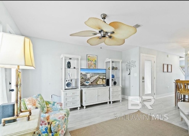 living room with ceiling fan, light wood-type flooring, visible vents, and baseboards