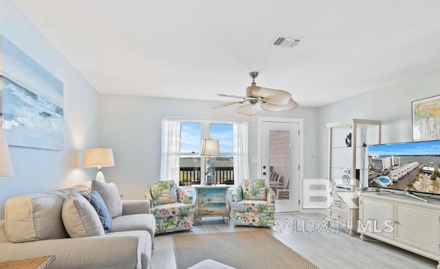 living room with ceiling fan, wood finished floors, and visible vents