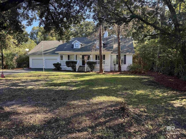 7228 Fairmont Dr, Foley, AL 36535 - new england style home featuring a porch, a garage, a front lawn, and driveway
