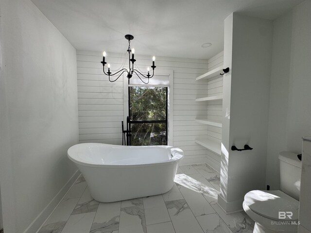 7228 Fairmont Dr, Foley, AL 36535 - bathroom with a freestanding tub, marble look tiles, a chandelier, baseboards, and wooden walls