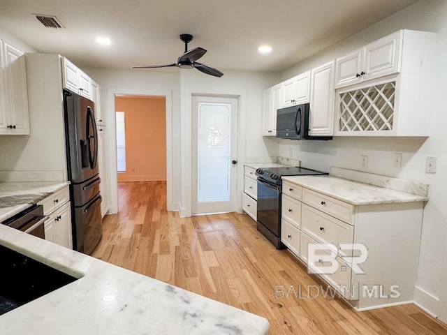 7228 Fairmont Dr, Foley, AL 36535 - kitchen with black appliances, light wood-type flooring, white cabinetry, a ceiling fan, and baseboards