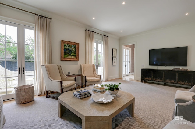 living room featuring a fireplace, french doors, light colored carpet, and ornamental molding