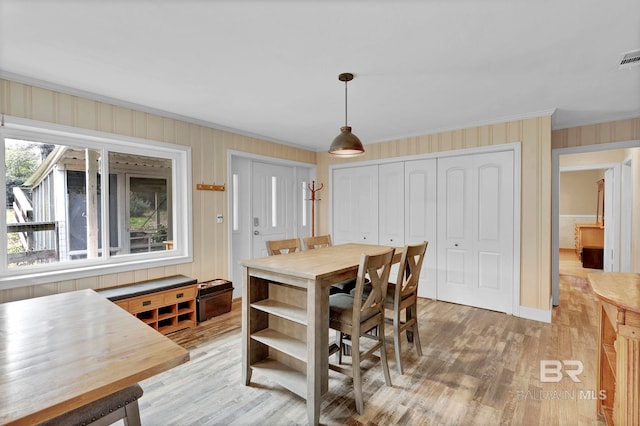 dining room featuring ornamental molding and light wood-type flooring