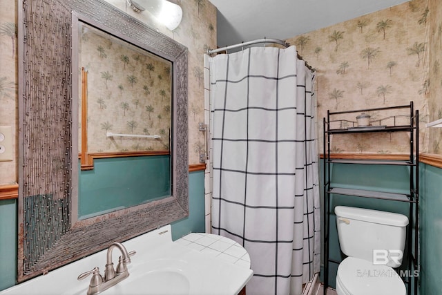 bathroom with toilet, curtained shower, and sink