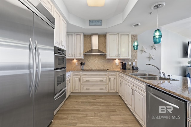 28107 Perdido Beach Blvd Unit D512, Orange Beach, AL 36561 - kitchen featuring stainless steel appliances, wall chimney range hood, tasteful backsplash, light wood finished floors, and light stone countertops