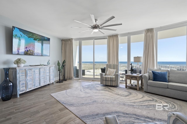 28107 Perdido Beach Blvd Unit D512, Orange Beach, AL 36561 - living room with expansive windows, a ceiling fan, wood finished floors, healthy amount of natural light, and a water view