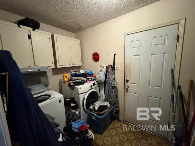 laundry room with cabinet space, independent washer and dryer, and a textured ceiling