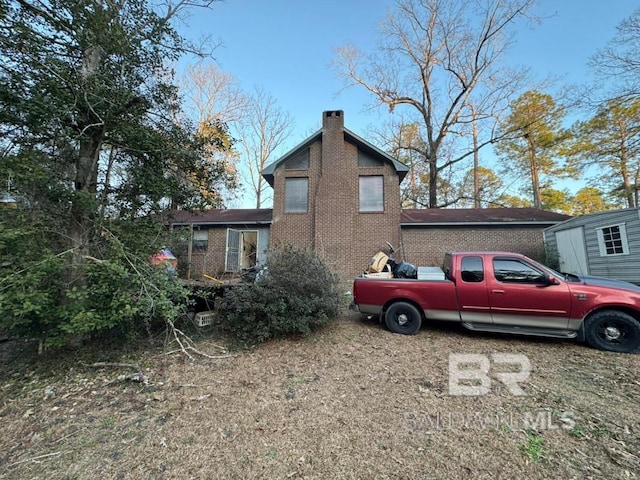 view of home's exterior featuring brick siding and a chimney