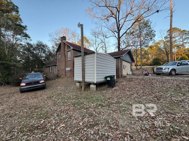 view of property exterior with brick siding and a chimney