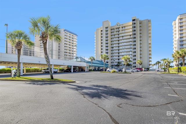 view of building exterior featuring uncovered parking and a city view