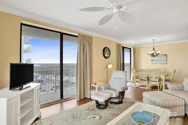 living room featuring ornamental molding, ceiling fan with notable chandelier, and wood finished floors