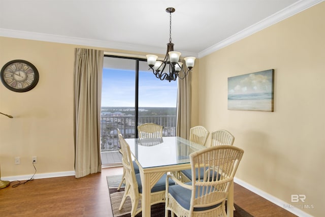 dining area with dark wood-style floors, a notable chandelier, ornamental molding, and baseboards