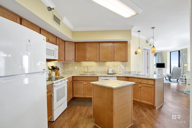 kitchen featuring white appliances, a center island, a peninsula, pendant lighting, and a sink