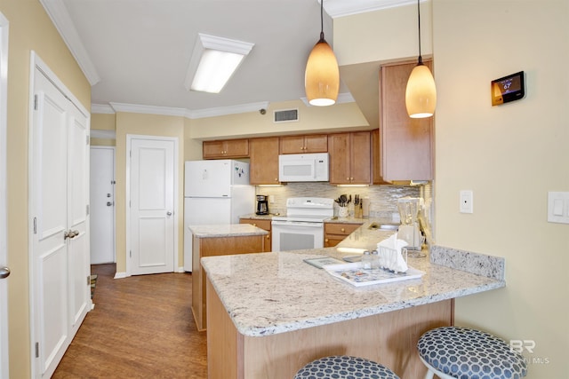 kitchen featuring pendant lighting, visible vents, white appliances, a peninsula, and a kitchen bar