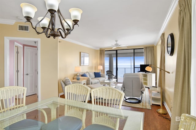 dining room featuring visible vents, ornamental molding, wood finished floors, baseboards, and ceiling fan with notable chandelier