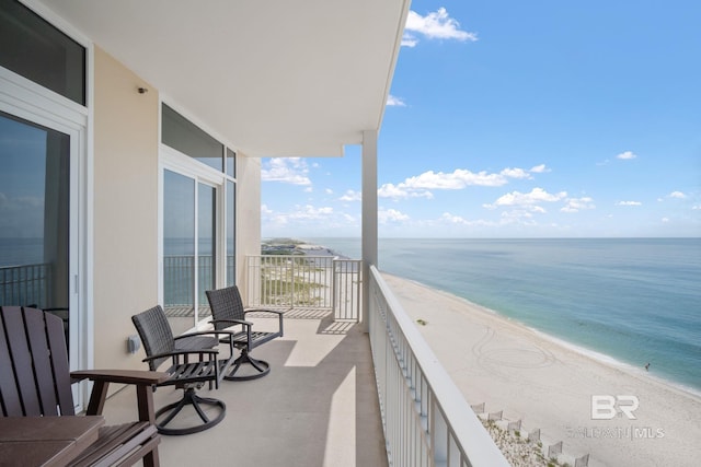 balcony featuring a view of the beach and a water view