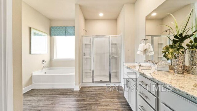 bathroom featuring vanity, hardwood / wood-style flooring, and shower with separate bathtub