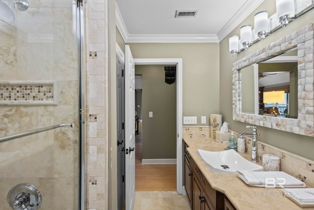 full bath with a ceiling fan, visible vents, a shower stall, vanity, and ornamental molding