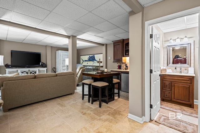 living room featuring stone finish floor and a paneled ceiling