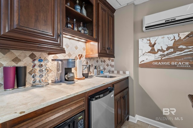 kitchen featuring dark brown cabinets, a sink, a wall mounted air conditioner, freestanding refrigerator, and backsplash