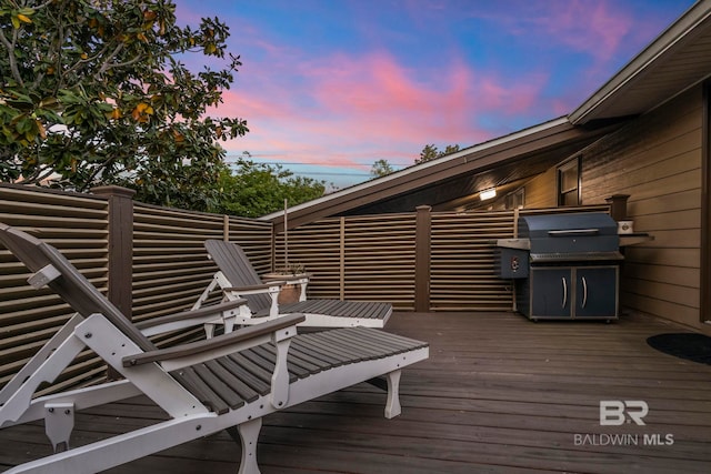 deck at dusk featuring area for grilling