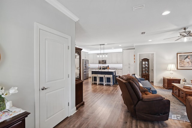 living room with ceiling fan, dark hardwood / wood-style floors, and crown molding