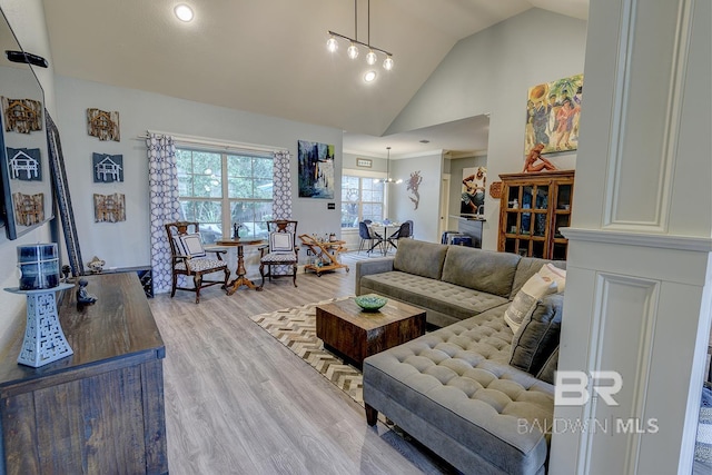 living room with high vaulted ceiling and light wood-type flooring