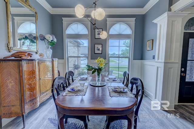 dining room with ornamental molding, hardwood / wood-style flooring, and ornate columns