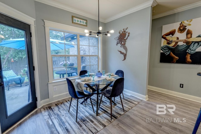 dining area with a notable chandelier, hardwood / wood-style floors, and ornamental molding