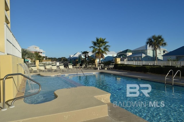 community pool with fence and a patio area