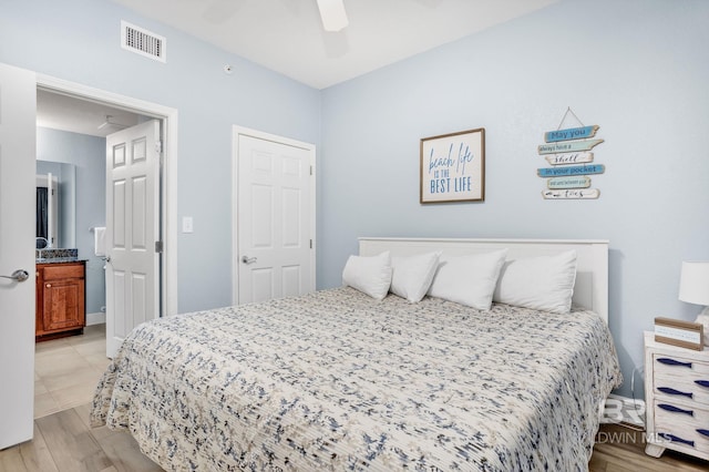 bedroom with a ceiling fan, light wood-type flooring, visible vents, and ensuite bathroom