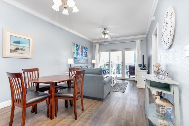 dining area featuring ceiling fan with notable chandelier, crown molding, baseboards, and wood finished floors