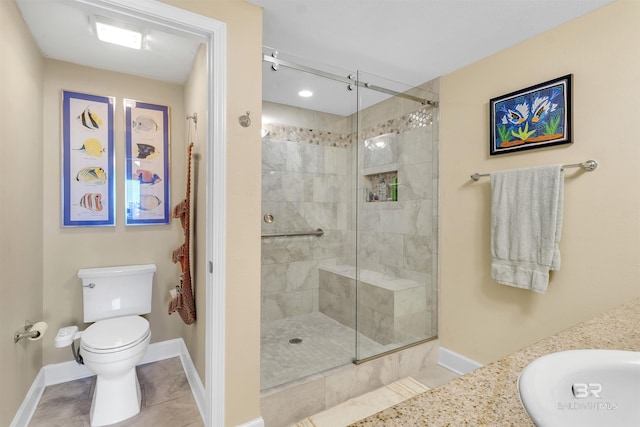 bathroom with a stall shower, a sink, toilet, and tile patterned floors