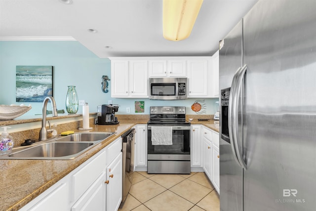 kitchen with light tile patterned floors, appliances with stainless steel finishes, ornamental molding, white cabinets, and a sink