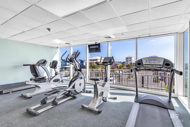 gym featuring a paneled ceiling, floor to ceiling windows, and visible vents