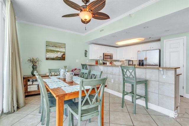 dining space featuring light tile patterned flooring, crown molding, and visible vents