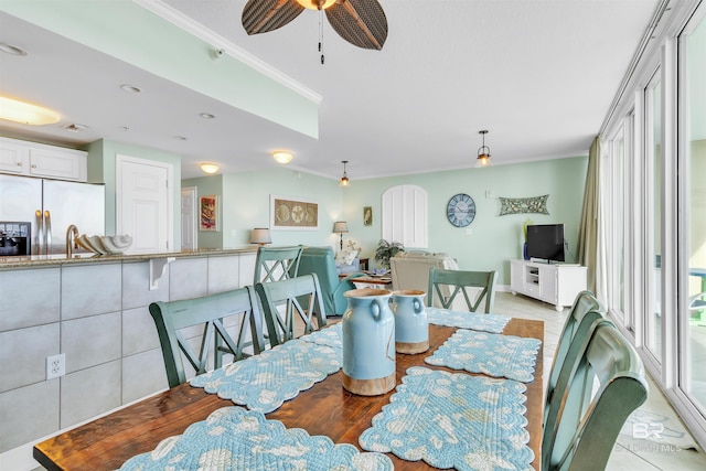 dining room featuring light tile patterned floors, ornamental molding, and a ceiling fan