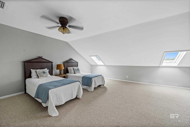 carpeted bedroom with a skylight, vaulted ceiling, baseboards, and a ceiling fan