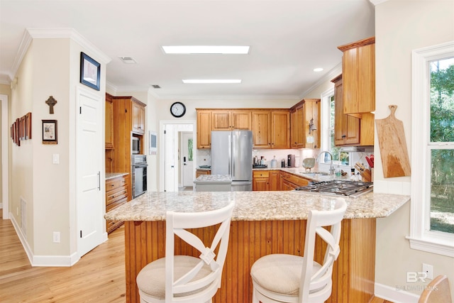 kitchen featuring a kitchen breakfast bar, kitchen peninsula, and appliances with stainless steel finishes