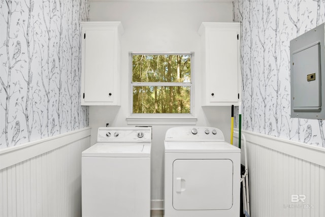 washroom with cabinets, electric panel, and washer and dryer