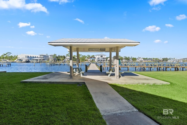 dock area with a lawn and a water view