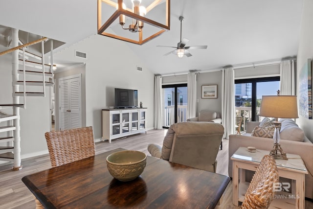 dining area with crown molding, hardwood / wood-style floors, high vaulted ceiling, and ceiling fan with notable chandelier