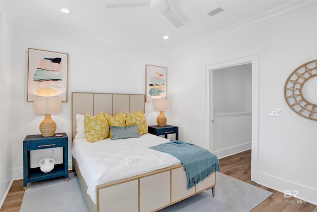bedroom with ceiling fan, crown molding, and light wood-type flooring