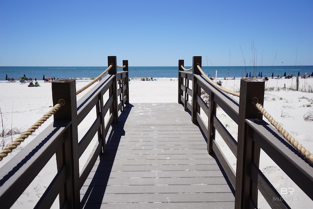 dock area with a beach view and a water view