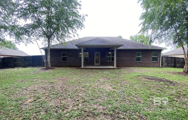 back of house with a lawn and a patio area