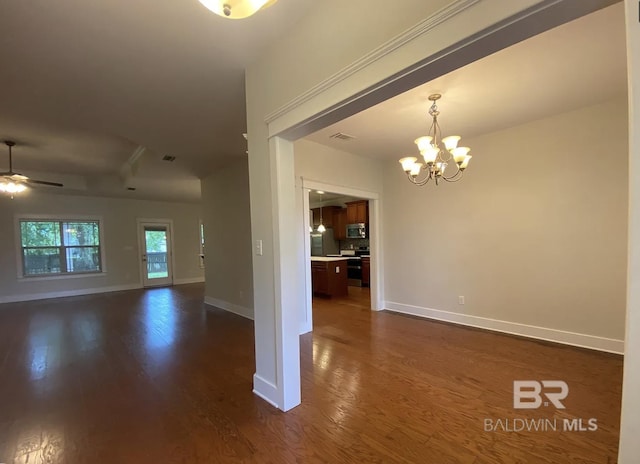 spare room featuring dark hardwood / wood-style floors and ceiling fan with notable chandelier