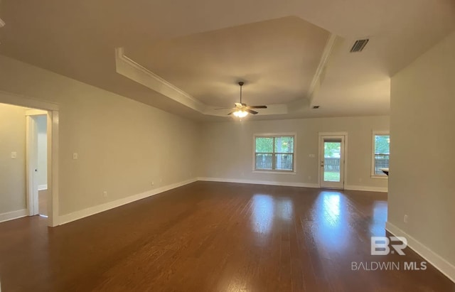 unfurnished living room featuring ceiling fan, dark hardwood / wood-style floors, and a raised ceiling