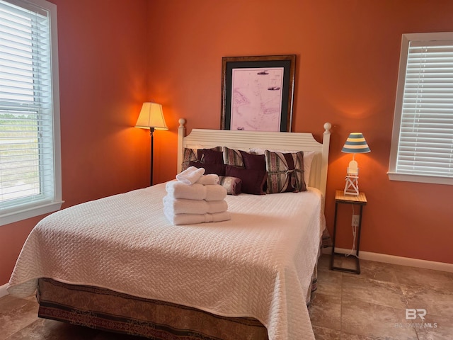 tiled bedroom featuring multiple windows